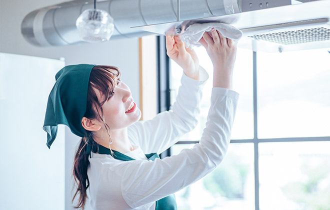 換気扇を掃除している女性スタッフ